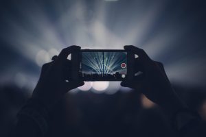 Hands holding smartphone while recording concert