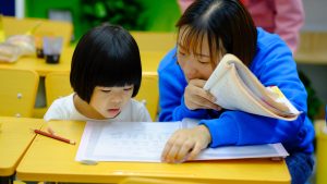 Teacher helping elementary student