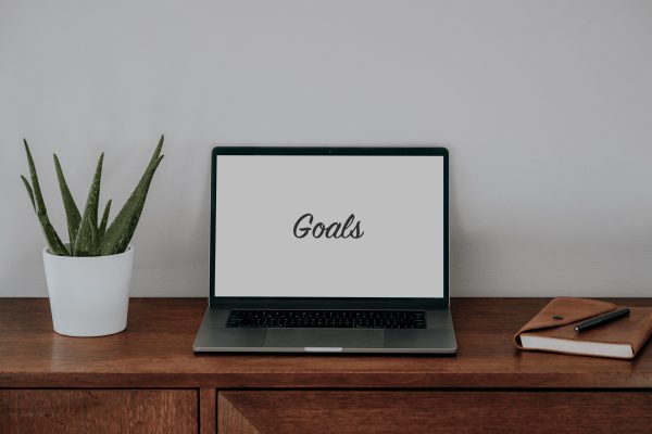 Laptop that says Goals on brown table